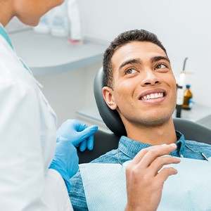 Patient smiling at dentist with pink mirror