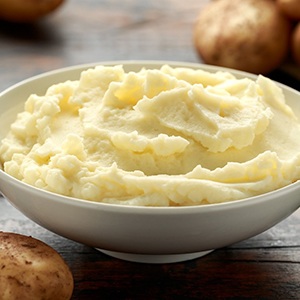 Bowel of mashed potatoes surrounded by whole potatoes